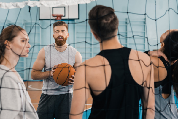 bearded young sportsman with ball talking
