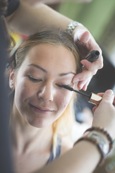 stylist applying mascara on woman s
