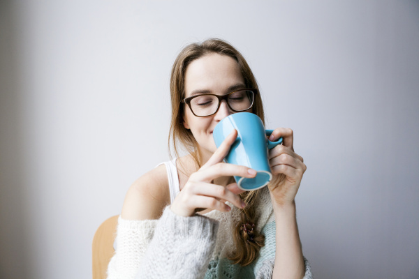 young woman at home drinking cup