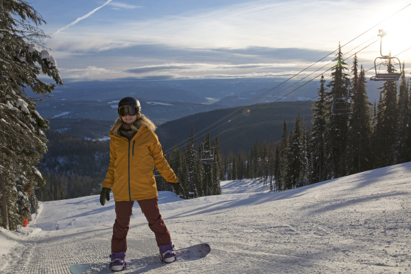 teen girl pauses on snowboard