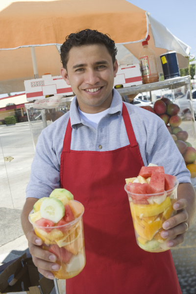 male street vendor holding fresh fruit