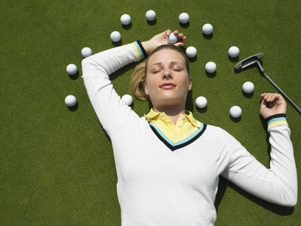 woman lying on putting green with