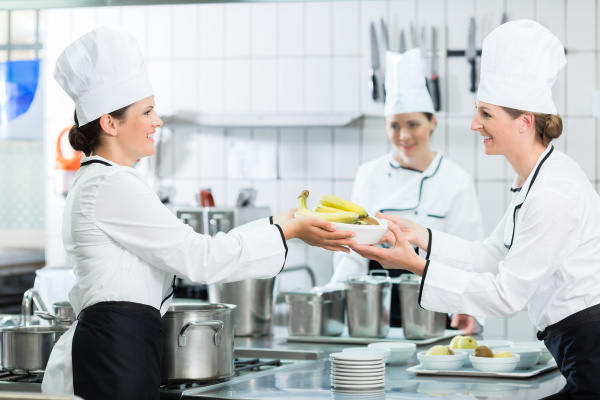 kitchen staff in canteen preparing dishes