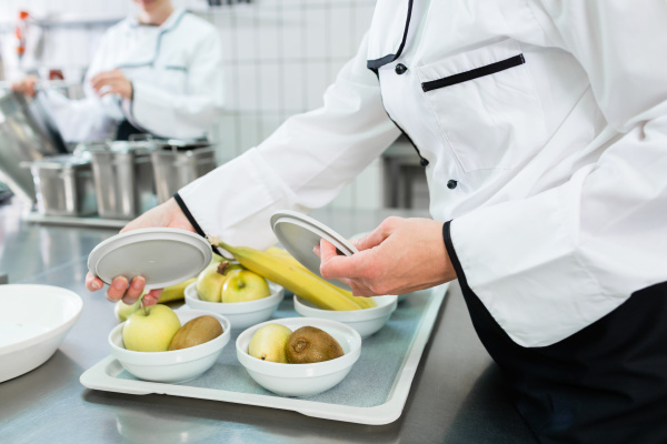chef preparing plates in canteen kitchen