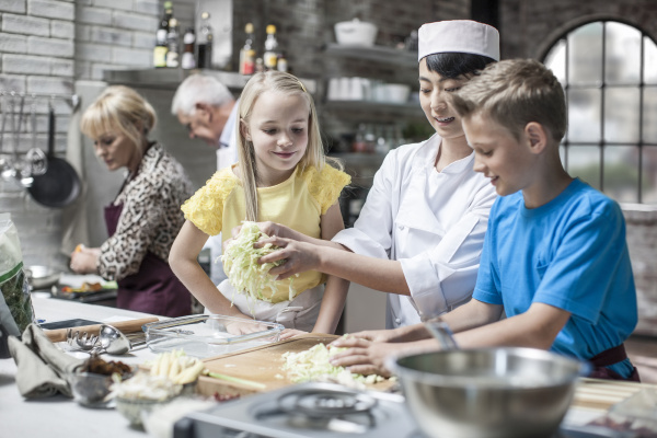 female chef instructing kids in cooking