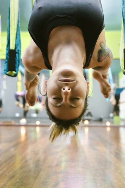 woman practicing aerial yoga in class