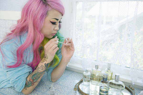 young woman applying nail polish