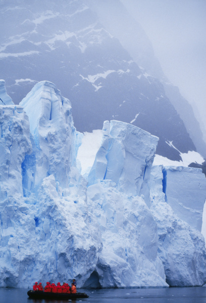 tourists exploring icebergs by zodiac