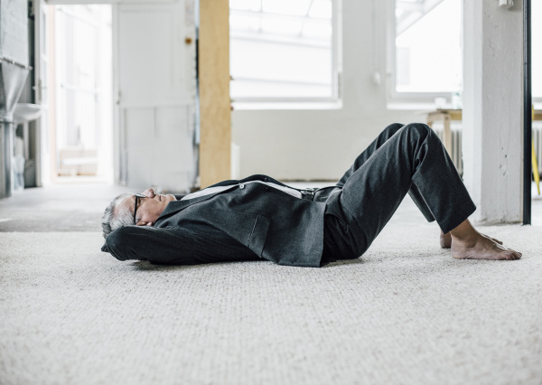 senior businessman lying on the floor