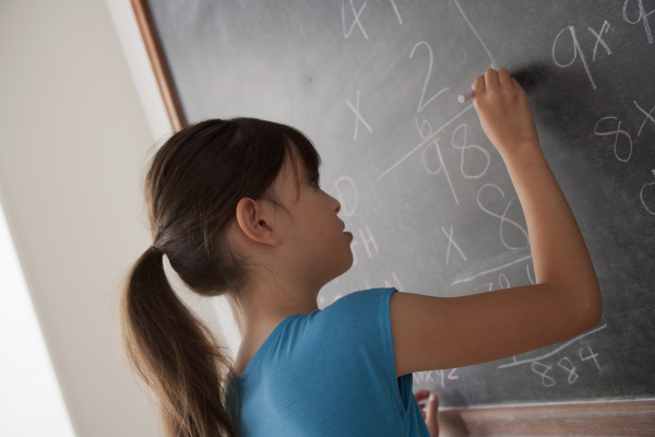 schoolgirl writing on blackboard