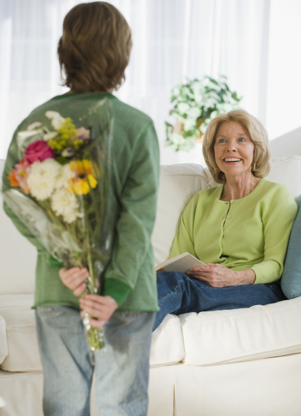 grandson surprising grandmother with flowers