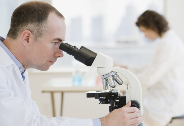 male scientist looking into microscope