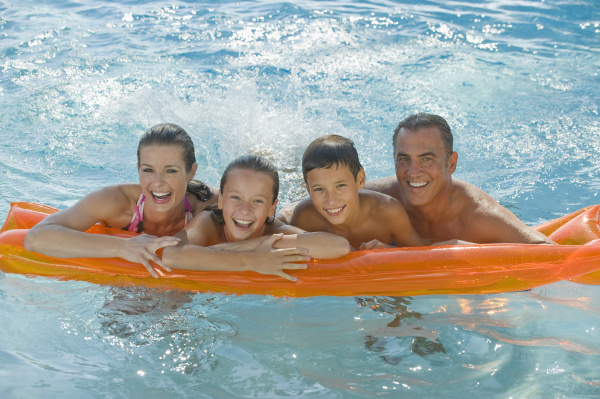 family resting on raft in swimming