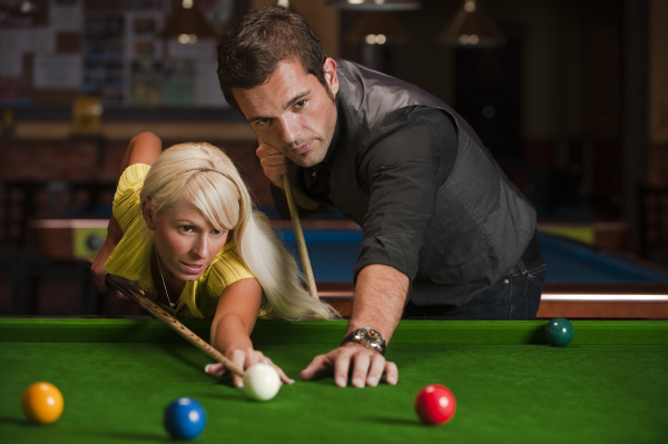 man and woman playing billiards