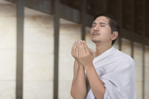 handsome asian hajj pilgrim praying