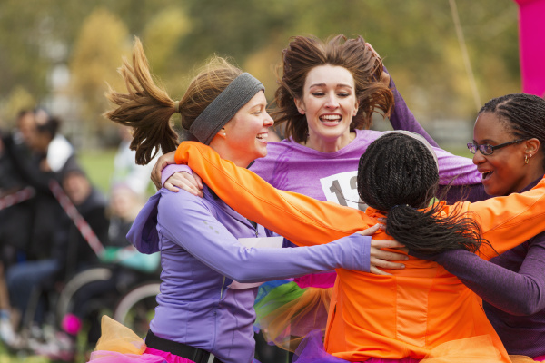 enthusiastic female runners finishing charity run