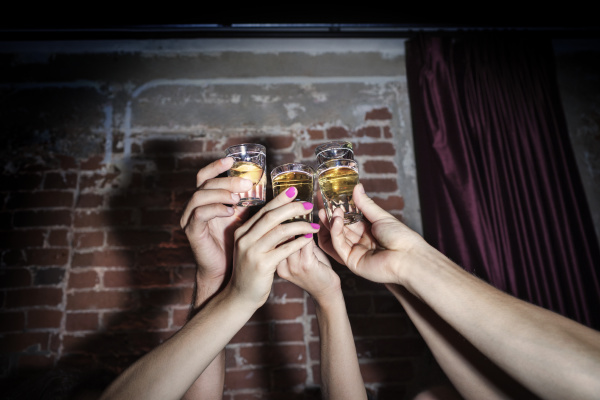 cropped image of friends toasting tequila