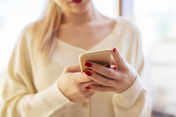 blonde woman using smartphone at home
