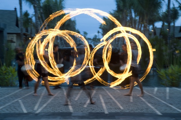 three fire twirlers performing bali