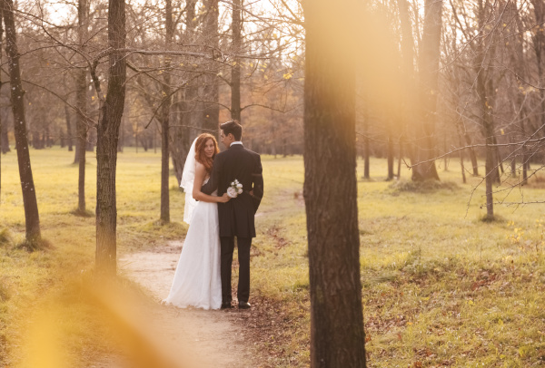 happy bridal couple embracing in park