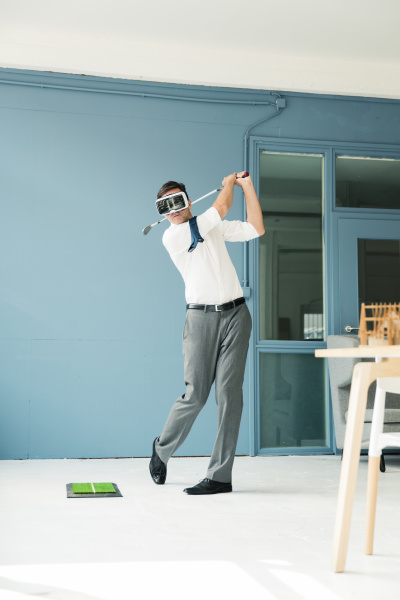 businessman wearing vr glasses playing golf