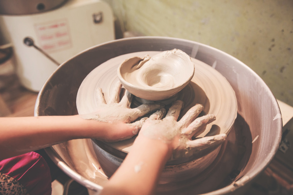 child hands working with clay on