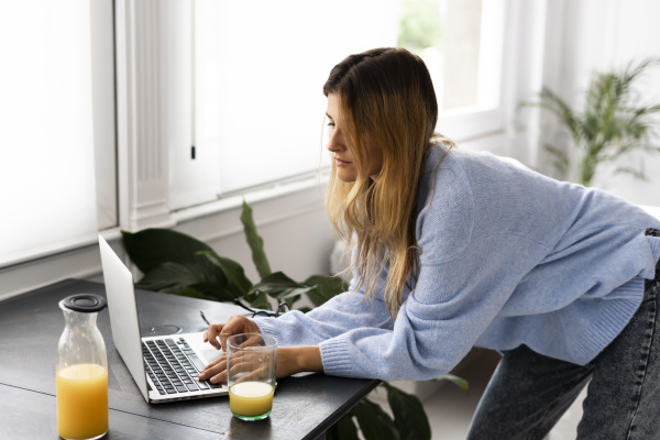 young woman using laptop at home