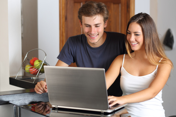 couple checking laptop content at home