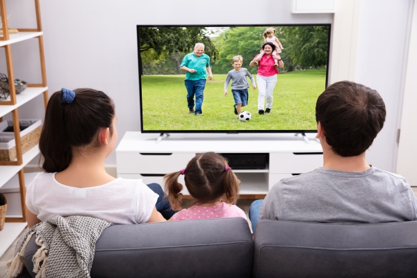 Family Sitting On Couch Watching Television - Stock image #26624218 ...