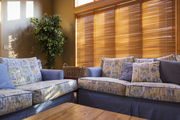 wood blinds behind sofas in living