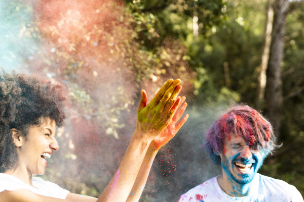 couple throwing colorful powder paint