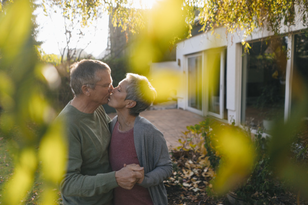 affectionate senior couple kissing in garden