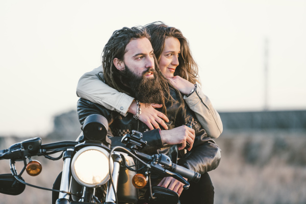 portrait of couple on motorbike looking