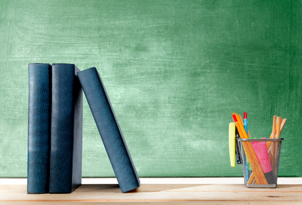 Pile of books standing and pencils in basket container - Stock image ...