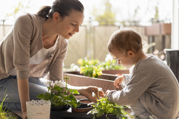 mother and daughter planting flowers together
