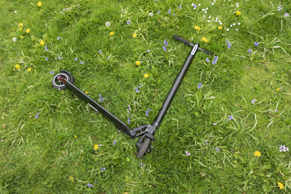 e scooter lying on flower meadow