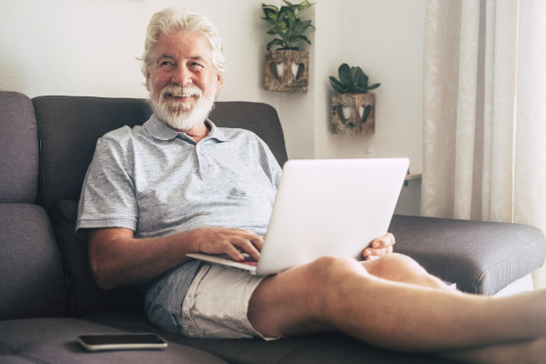 smiling senior man using laptop on