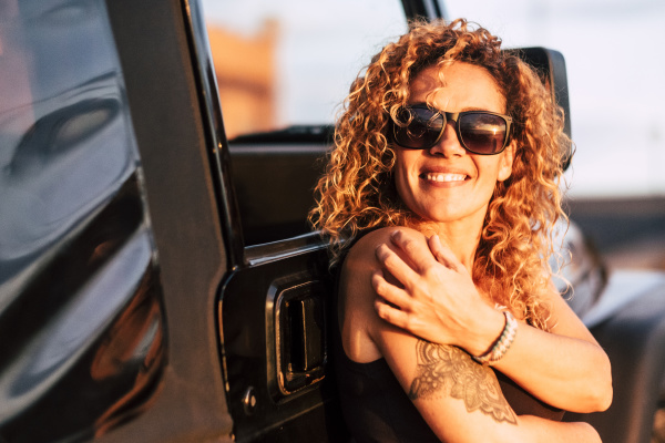 smiling woman wearing sunglasses with arm