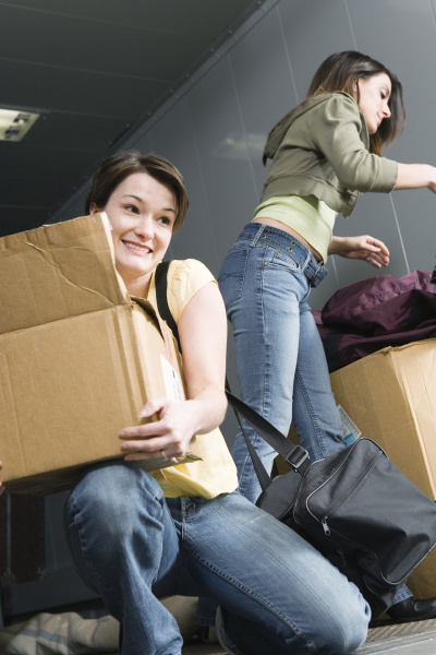 women packing her belongings in cardboard