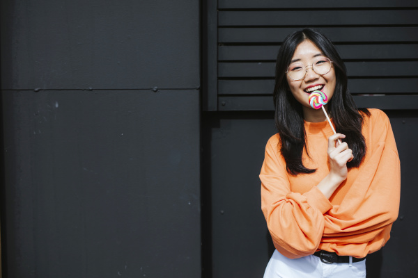 young asian woman with lollipop in
