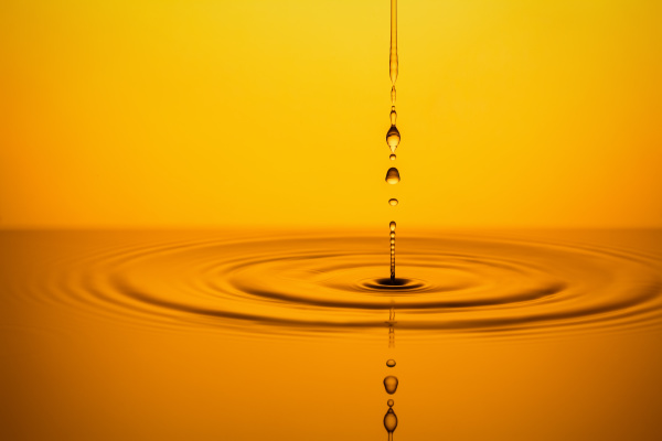 golden oil drops on yellow background