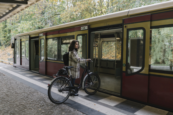 woman with bicycle entering an underground