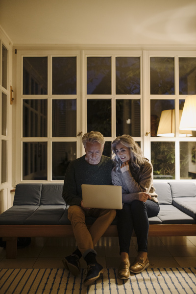 senior couple using laptop on couch