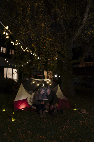 senior couple with tablet camping in