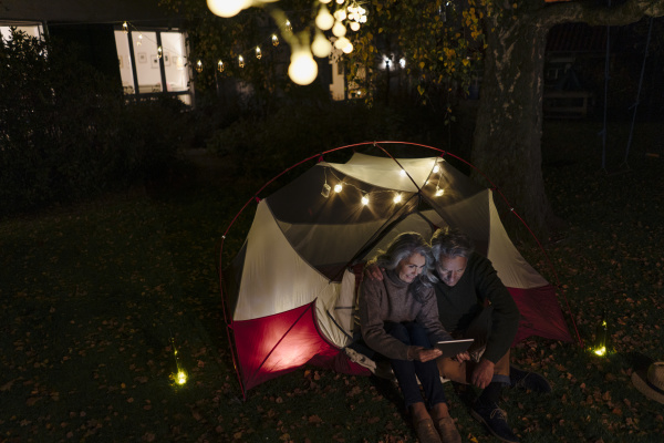 senior couple with tablet camping in