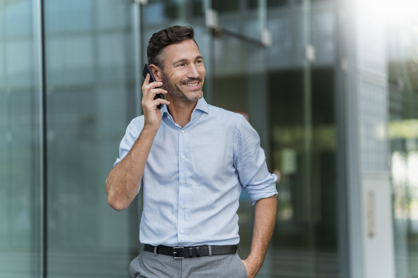 smiling businessman on cell phone in