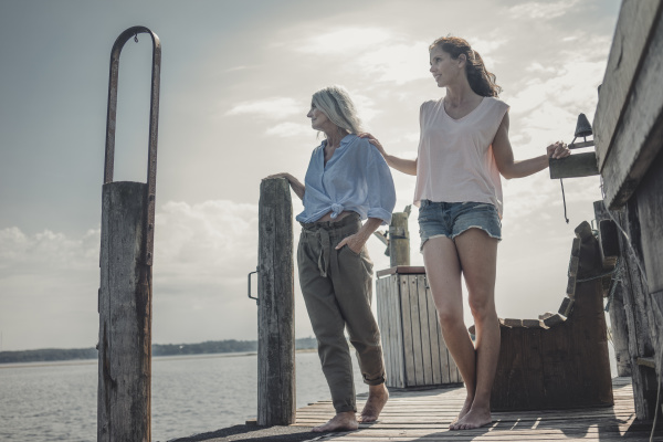 mother and daughter standing on jetty