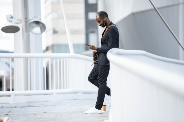 young businessman with earphones standing on