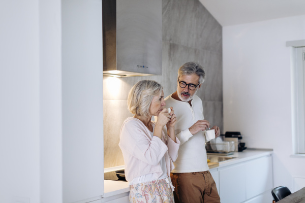 mature couple drinking coffee in kitchen