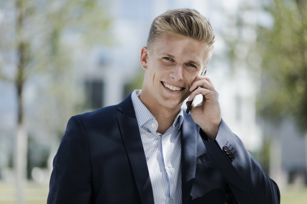 portrait of smiling young businessman talking
